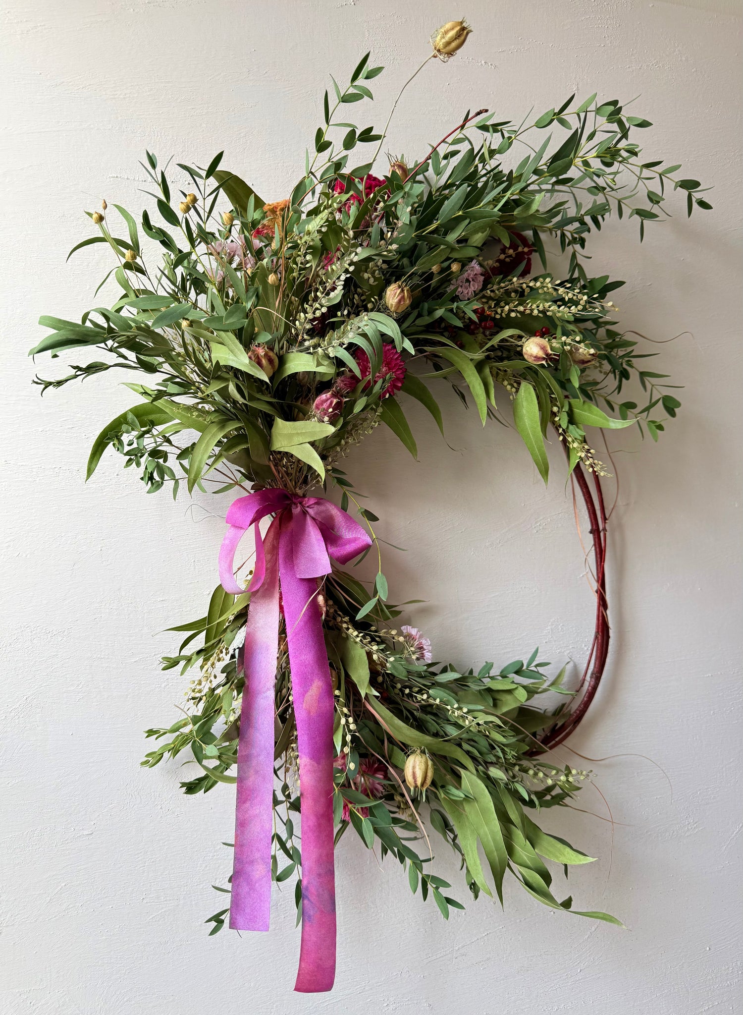 Handcrafted CHRYSALIS botanical wreath with strawflowers, eucalyptus, nigella, and natural grasses on a vine base in soft earthy tones.