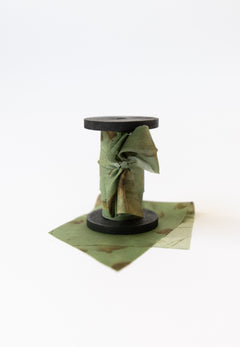 Botanical print silk ribbon in natural earthy tones displayed on FSC-certified wooden spools for wreath and floral styling.